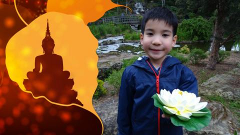 Young boy holding flower offering, next to illustration of the Buddha.