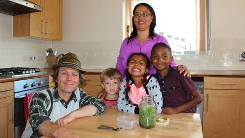 Mr Bloom and a family with a jar of Microgreens