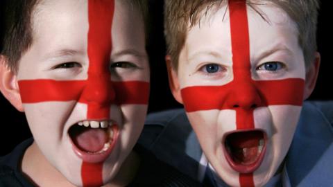 Two boys with England flags painted on their faces.