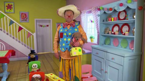 Mr Tumble plays some games inside his home.