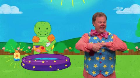 Mr Tumble exercises outside with his friends.