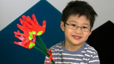 A young boy holding the Valentines make.