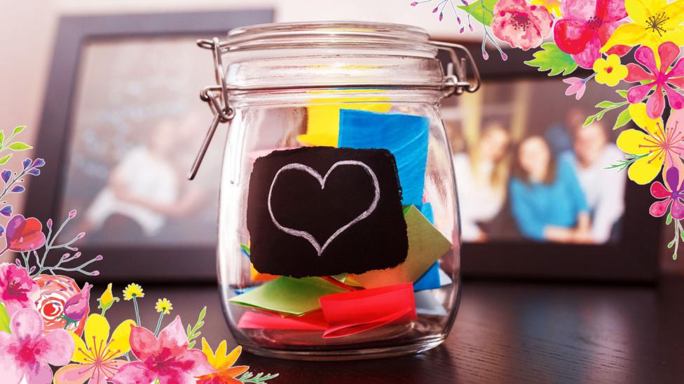 A glass jar filled with small paper notes.