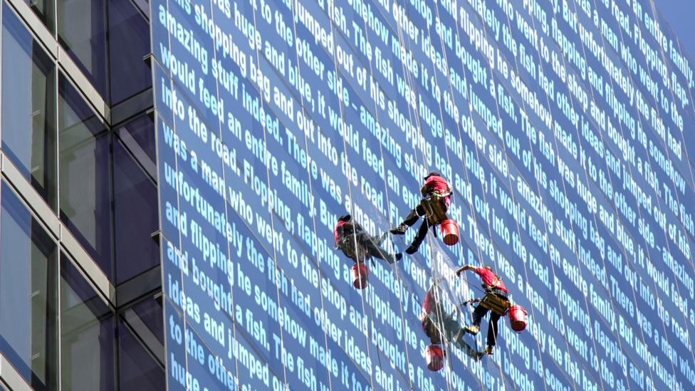 An abseiler with words on a building.