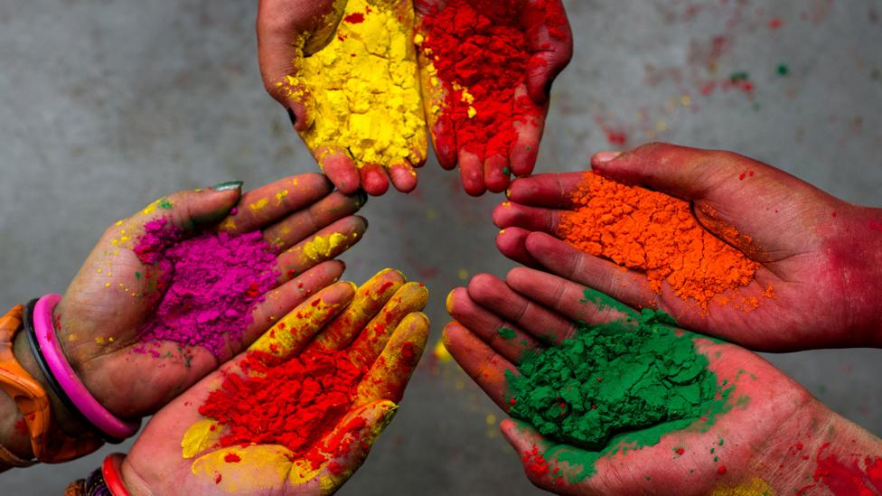 Some hands showing colour powder during Holi festival in India.