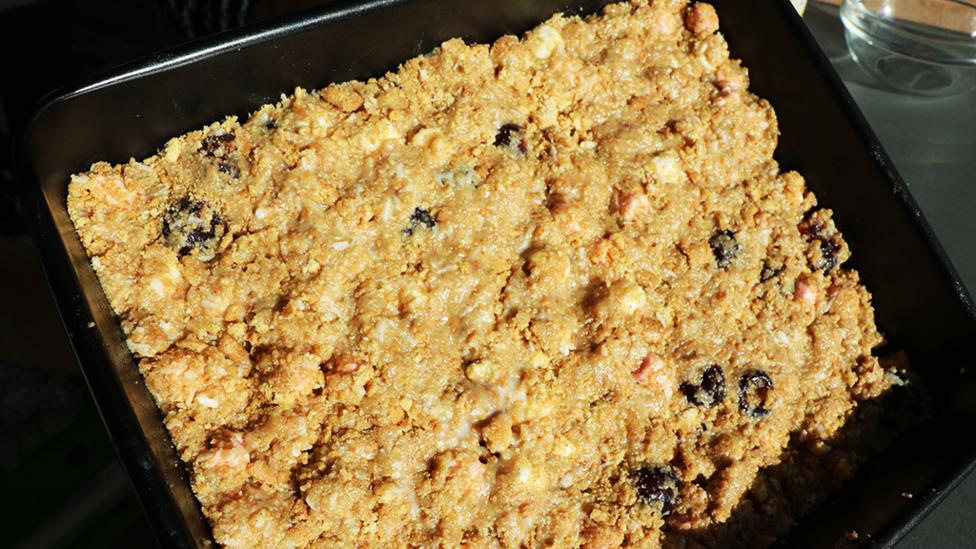 Crushed digestive biscuits, desiccated coconut, cherries, marshmallows and condensed milk all mixed together and flattened into a tray.