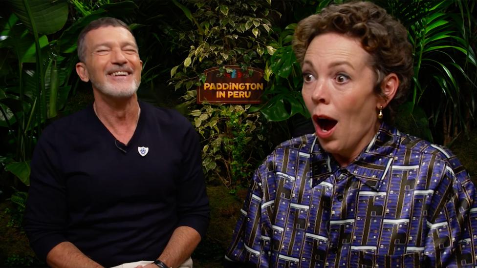 Olivia COlman and Antonio Banderas, actors in the film Paddington in Peru, react to earning their Blue Peter badges.