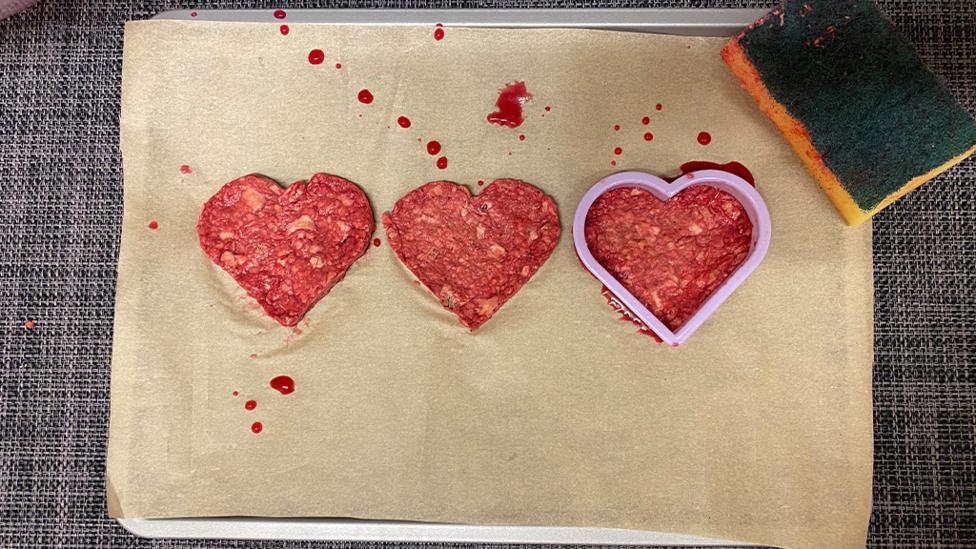 Three heart shapes, made from wet red paper.