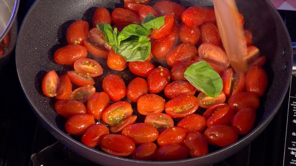 Cherry tomato sauce in frying pan.