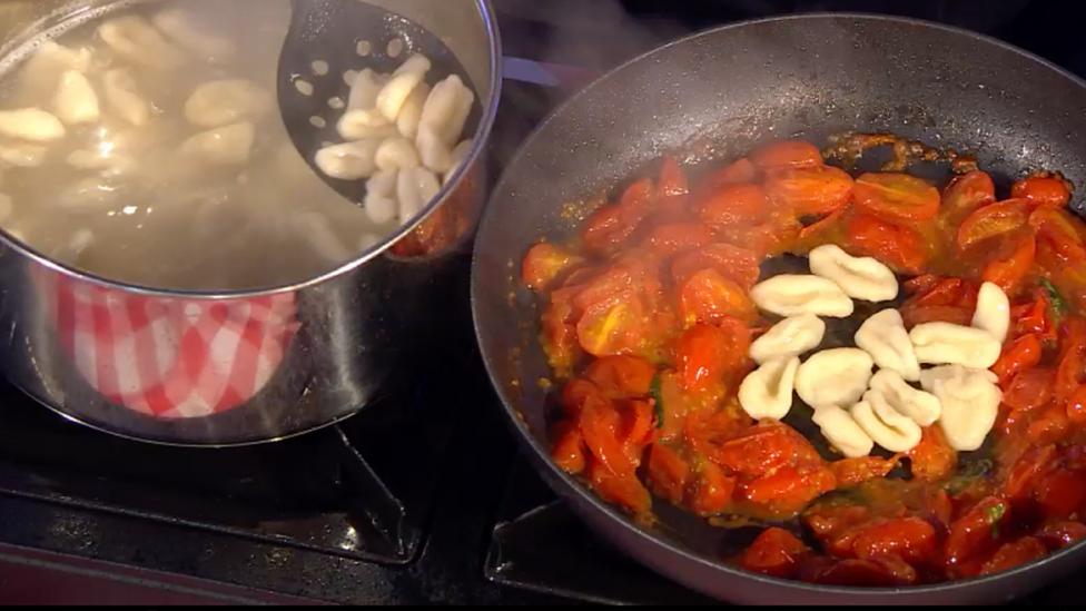 Cherry tomato sauce in frying pan.