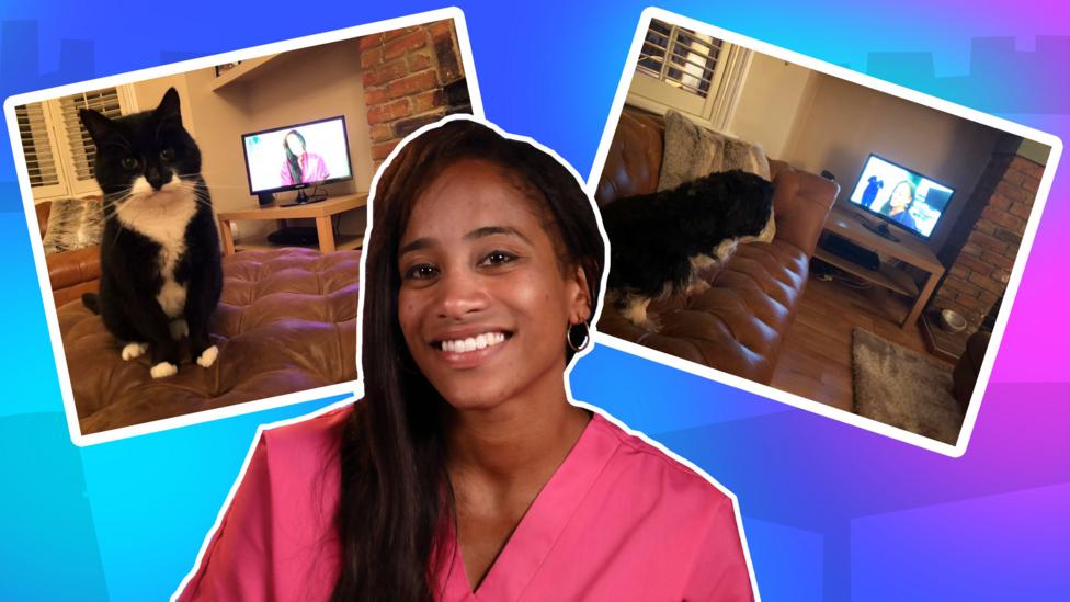 Two photos behind female vet with dark hair and pink scrubs. Pic on left is of a cat. Pic on right is a dog on the sofa.