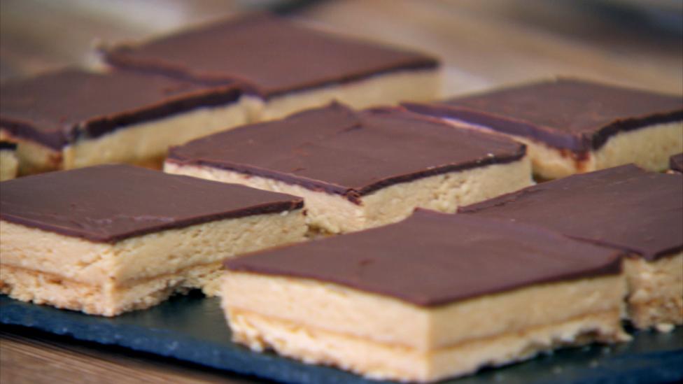 Shortbread peanut butter squares on a slate tray.