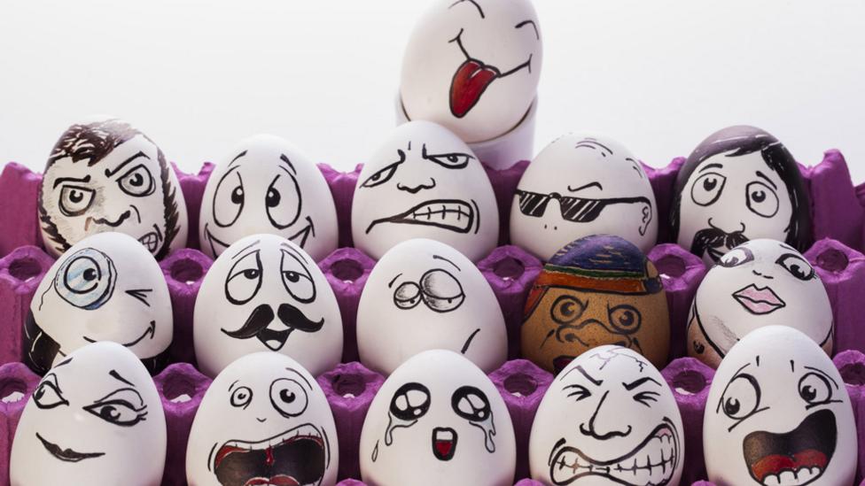 carton of eggs with drawn on faces