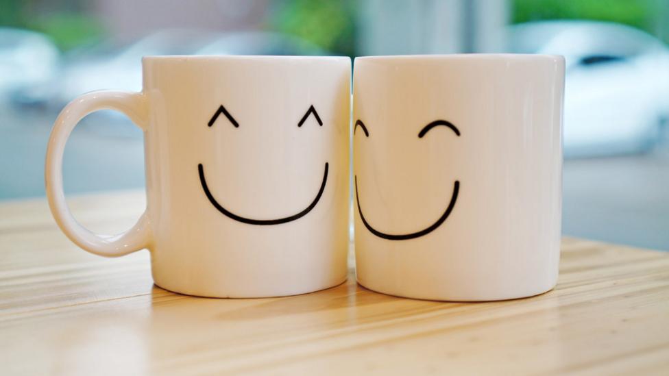 Two mugs smiling and being friendly