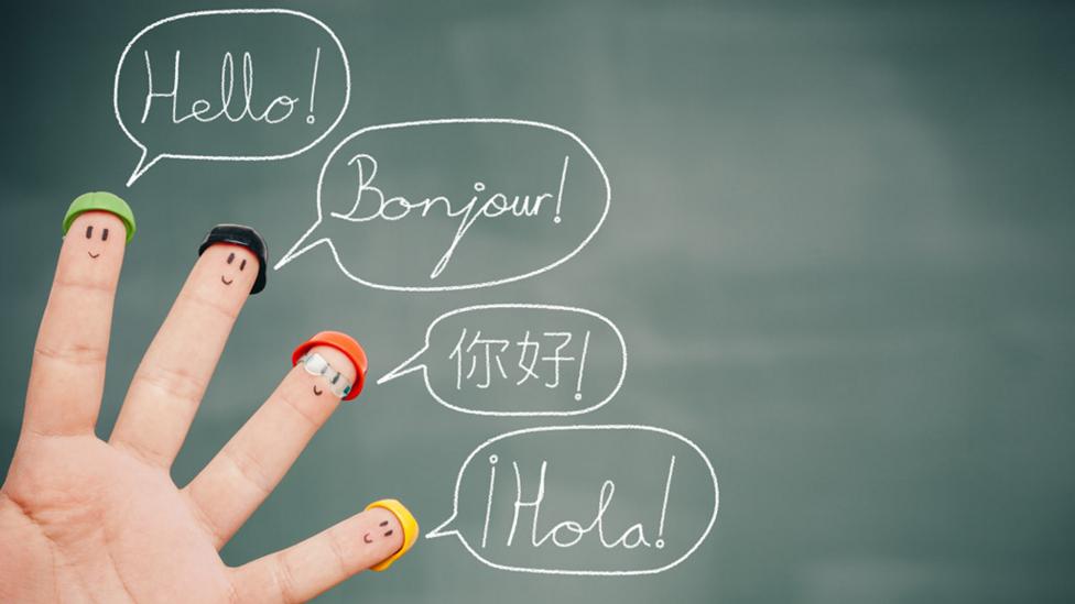 Fingers of a hand saying hello in different languages