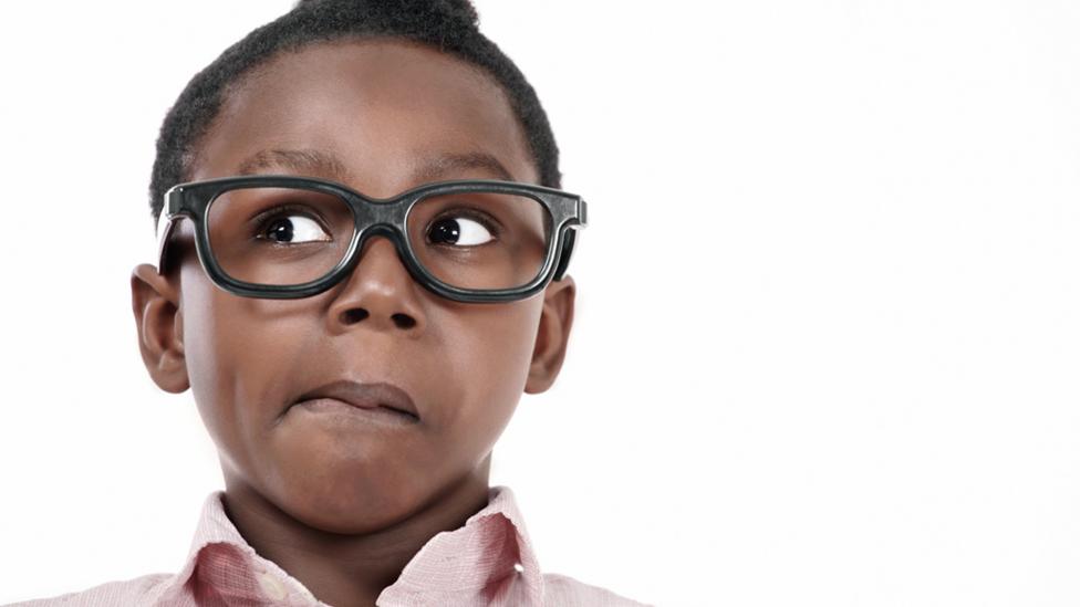 boy wearing glasses making a funny face