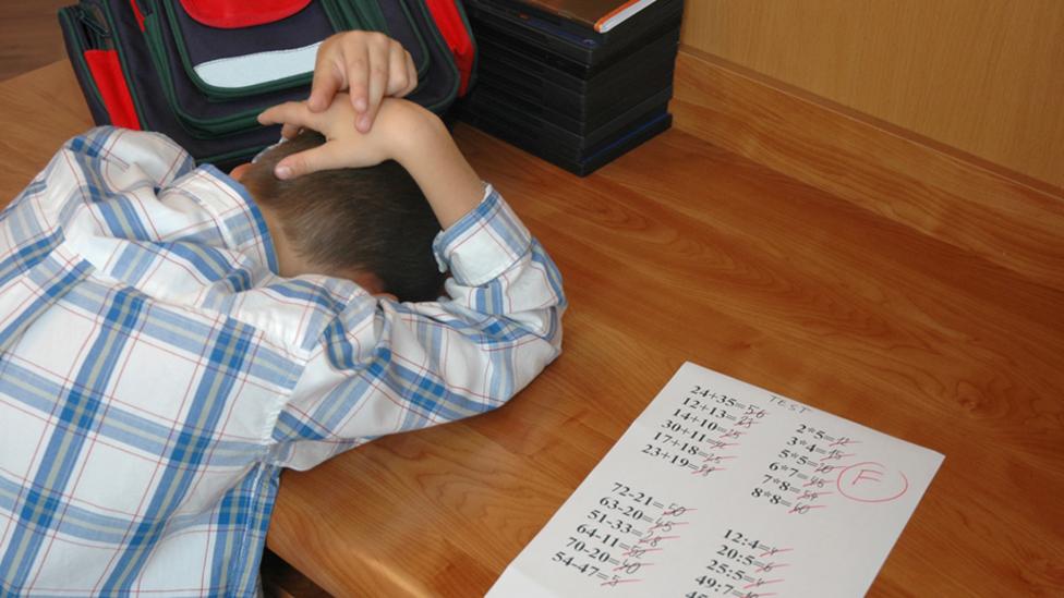 boy with head down on desk failed test