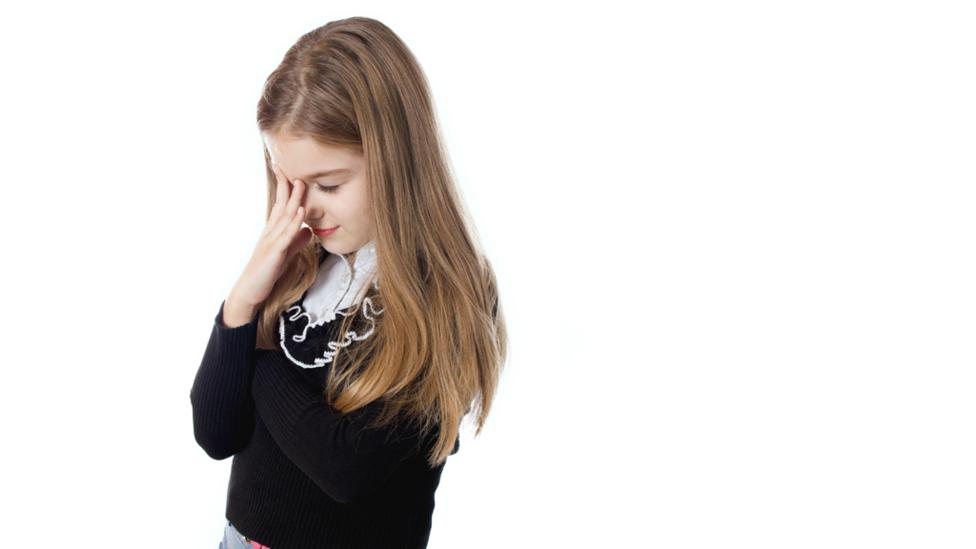 School girl upset covering her face