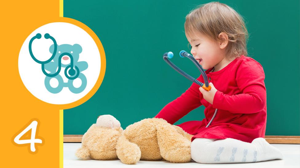 A little girl kneeling over a teddy bear and holding a stethoscope