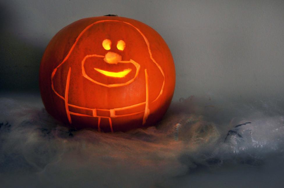 A pumpkin with a Duggee carving is sat in the distance in a dark and foggy setting