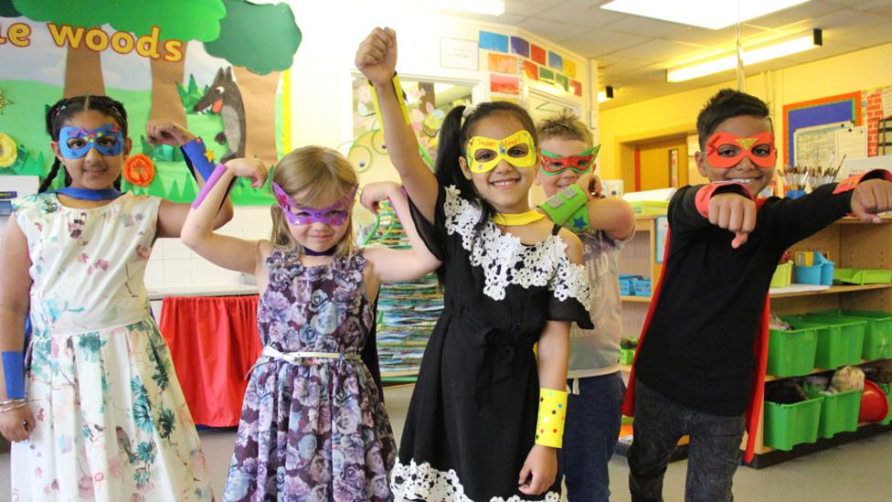 Four children dressed as superheros