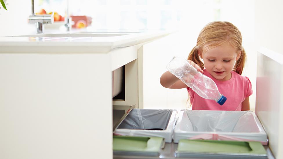 child recyling bottles for recycling listicle