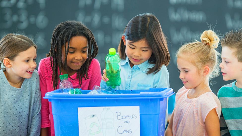 Children sorting recycling in to a box