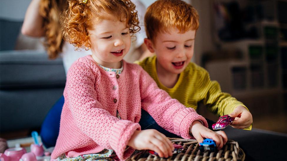 little boy and girl racing toy cars