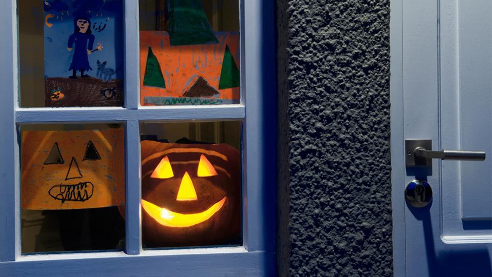 Halloween pictures and pumpkin in window