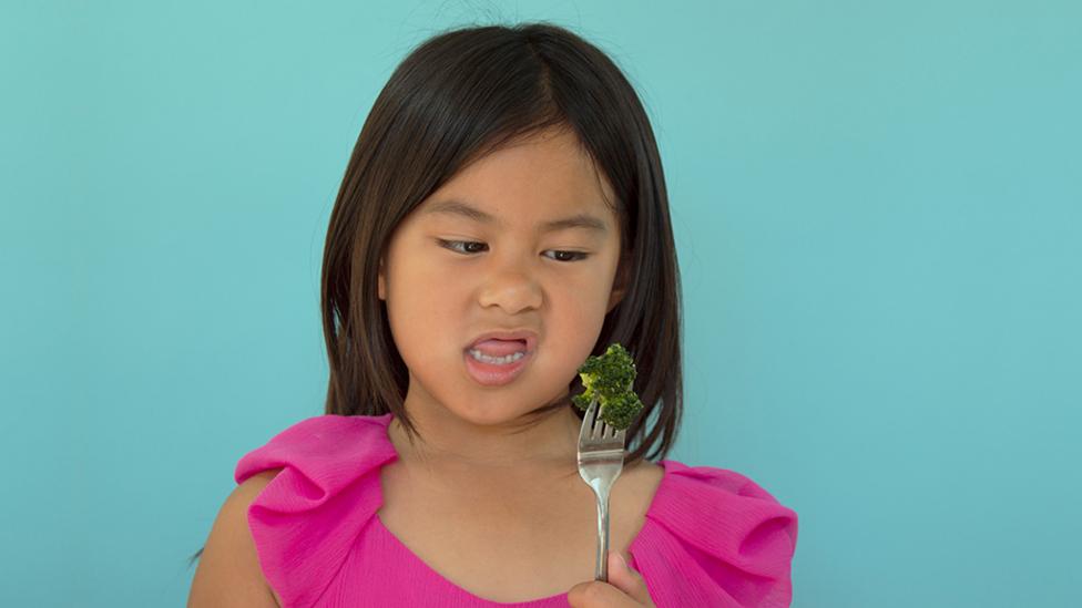 Little girl with broccoli