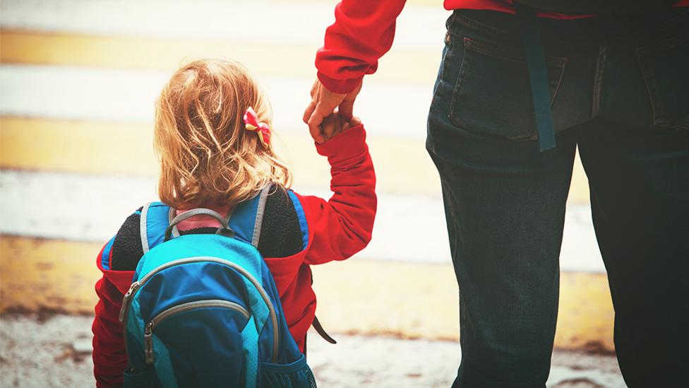 Parent holding child's hand