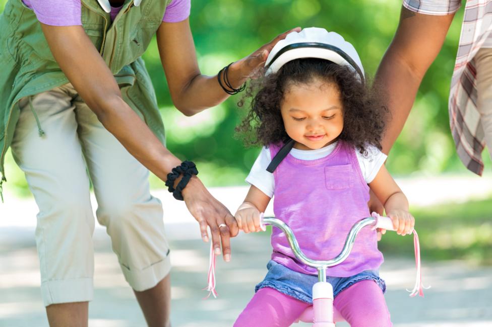 little girl cycling with her parents.