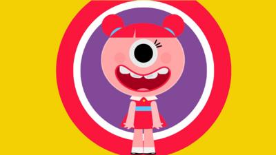 A young girl with pink hair is two bunches with a fringe. She has one big eye in the centre of her face, with a large mouth smiling and showing teeth. She is wearing a red dress with a blue belt and a white collar.