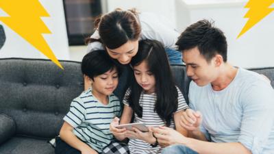 Picture of parents looking at phone with son and daughter
