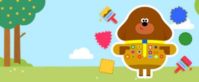 Duggee standing next to lots of badge pieces.