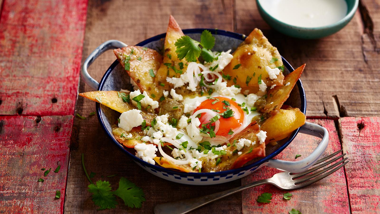 Fried eggs and green salsa on tortilla chips (chilaquiles)