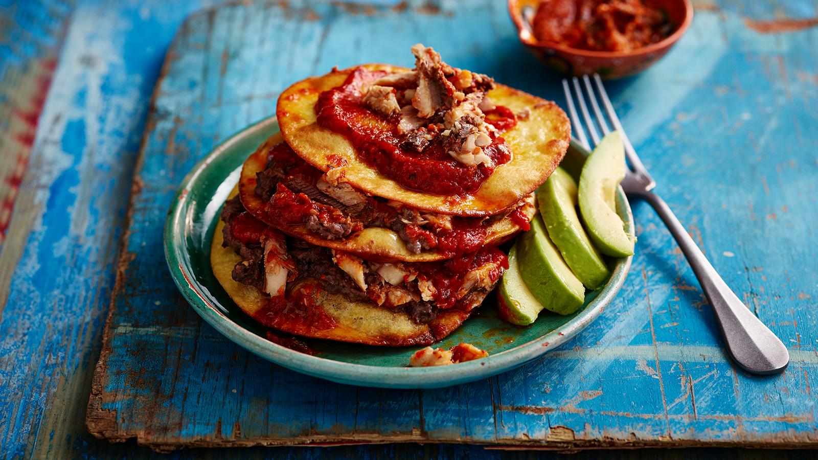 Sardines in tortillas with spicy tomato sauce and refried beans