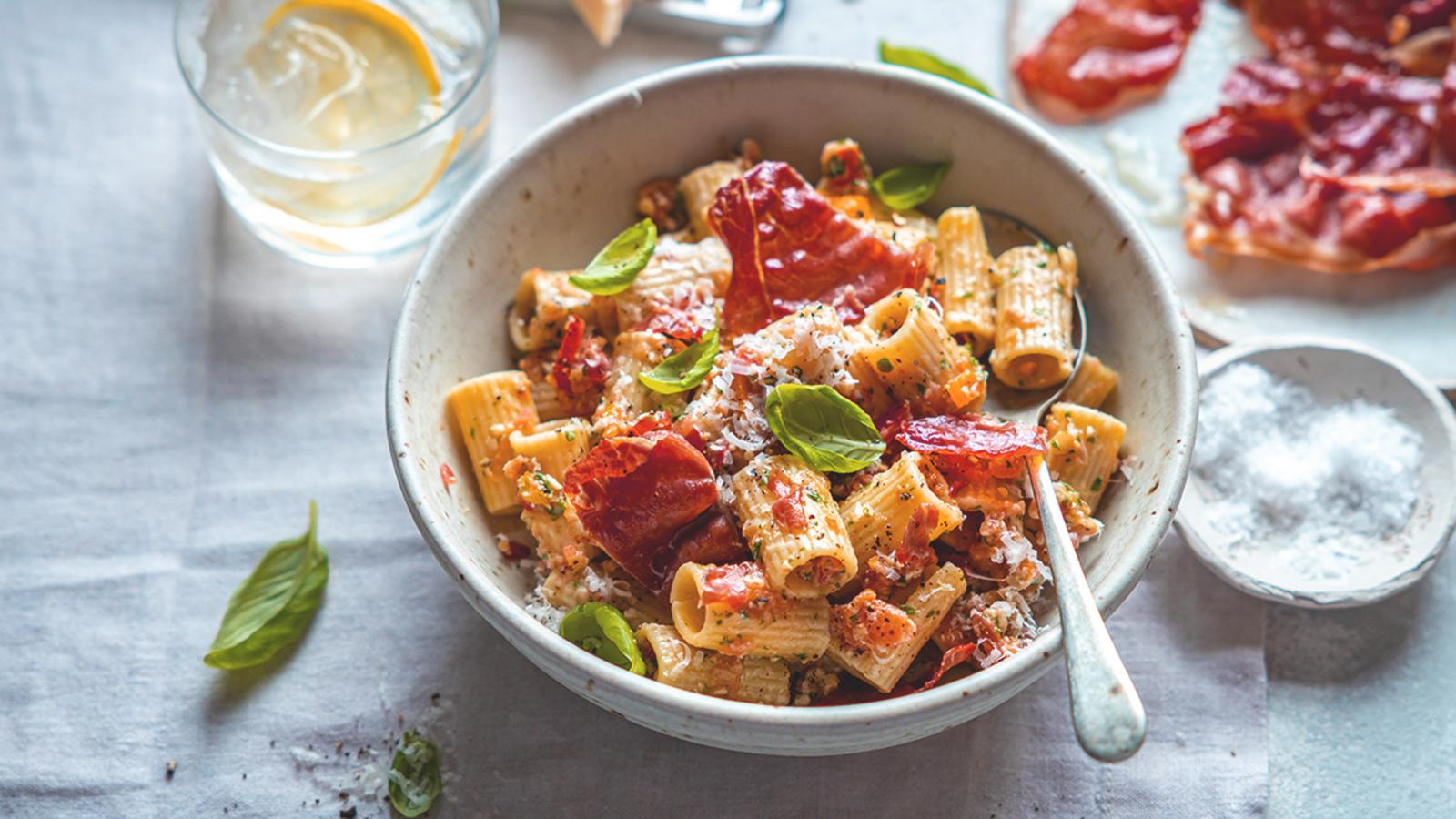 Chopping board tomato and basil pesto pasta