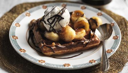 Waffles with hot chocolate sauce, fried bananas and ice cream