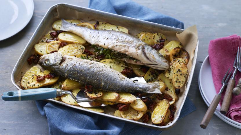 Whole baked fish with potatoes, lemon and sundried tomatoes