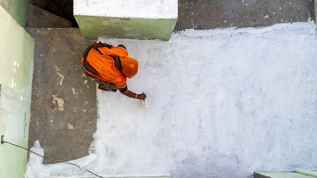 Mitul Kajaria A woman paints the roof of her home with white paint (Credit: Mitul Kajaria)