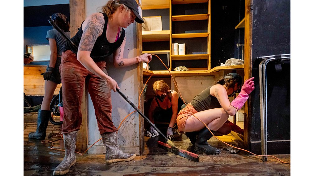 Getty Images Clara Walsh, Rachel Farrell and Erika McCormick help clean up Three Penny Taproom in Montpelier, Vermont, after damage due to major flooding in July 2023 (Credit: Getty Images)