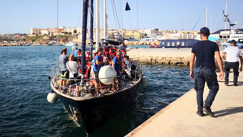 Italy migrants: Migrants allowed off charity ship despite ban - BBC News