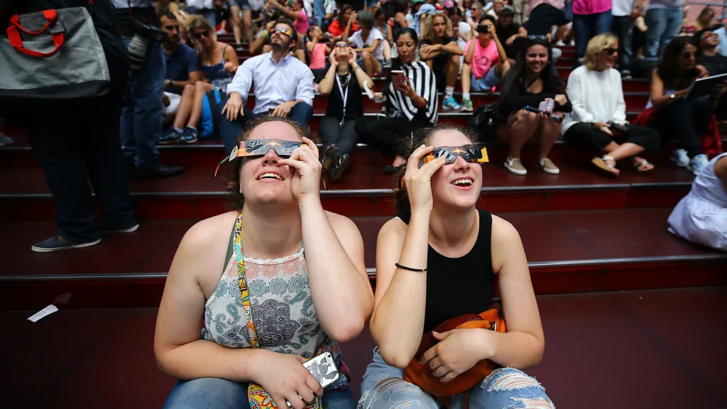 Young women watching 2017 eclipse in Time Square, New York City (Credit: Getty Images)