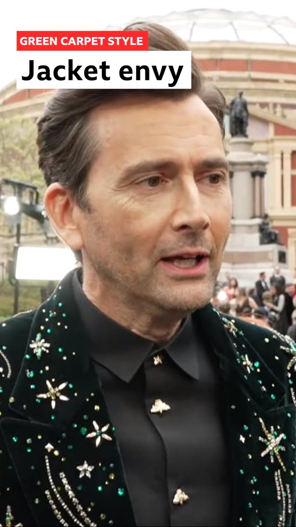 David Tennant on the green carpet in a star studded jacket