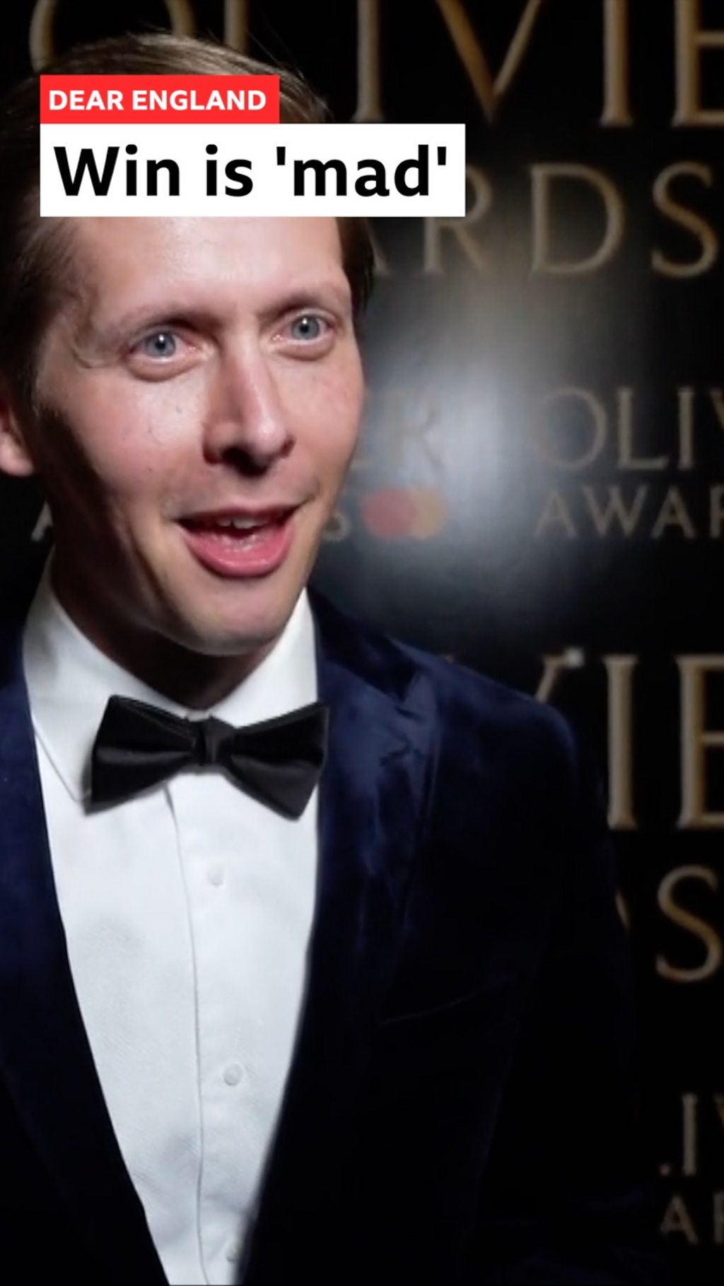 Actor Will Close wearing tuxedo and bowtie holding his Olivier Award