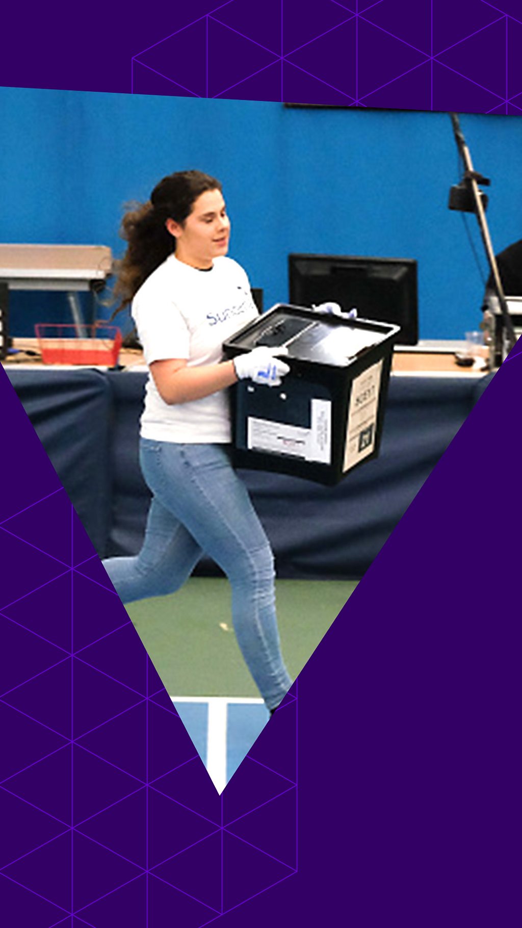 A young woman running with a ballot box in a counting centre with a purple triangle graphic on top