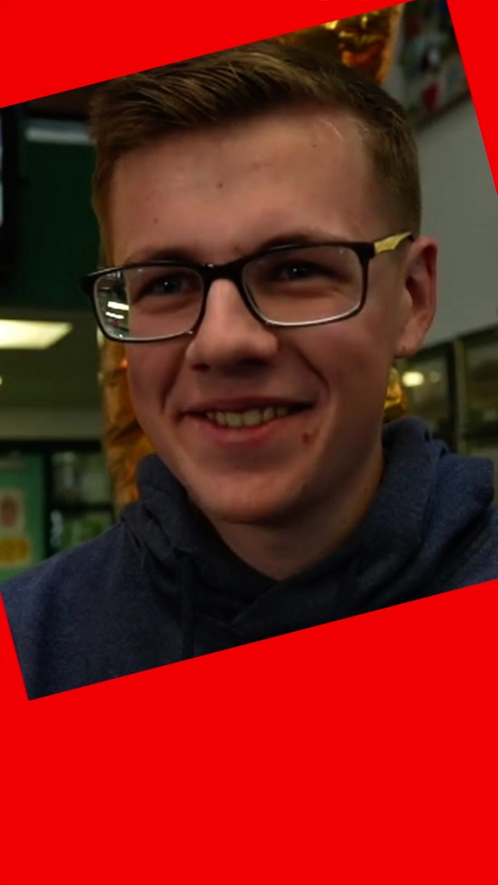 Student wearing glasses smiles at the camera