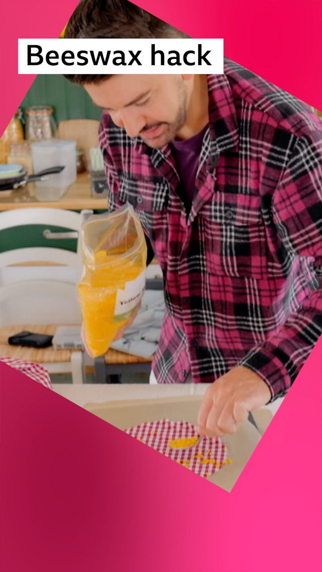 Man, Iwan Carrington, wears a red checked shirt as he sprinkles beeswax on to fabric