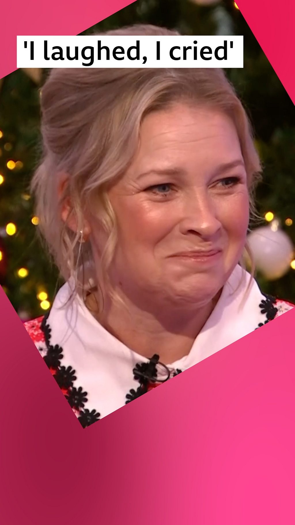 A woman, Joanna Page, smiles - she has long blonde hair tied back and wears a red dress with a white collar